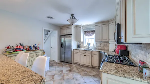 a kitchen with stainless steel appliances granite countertop a stove a sink and a refrigerator