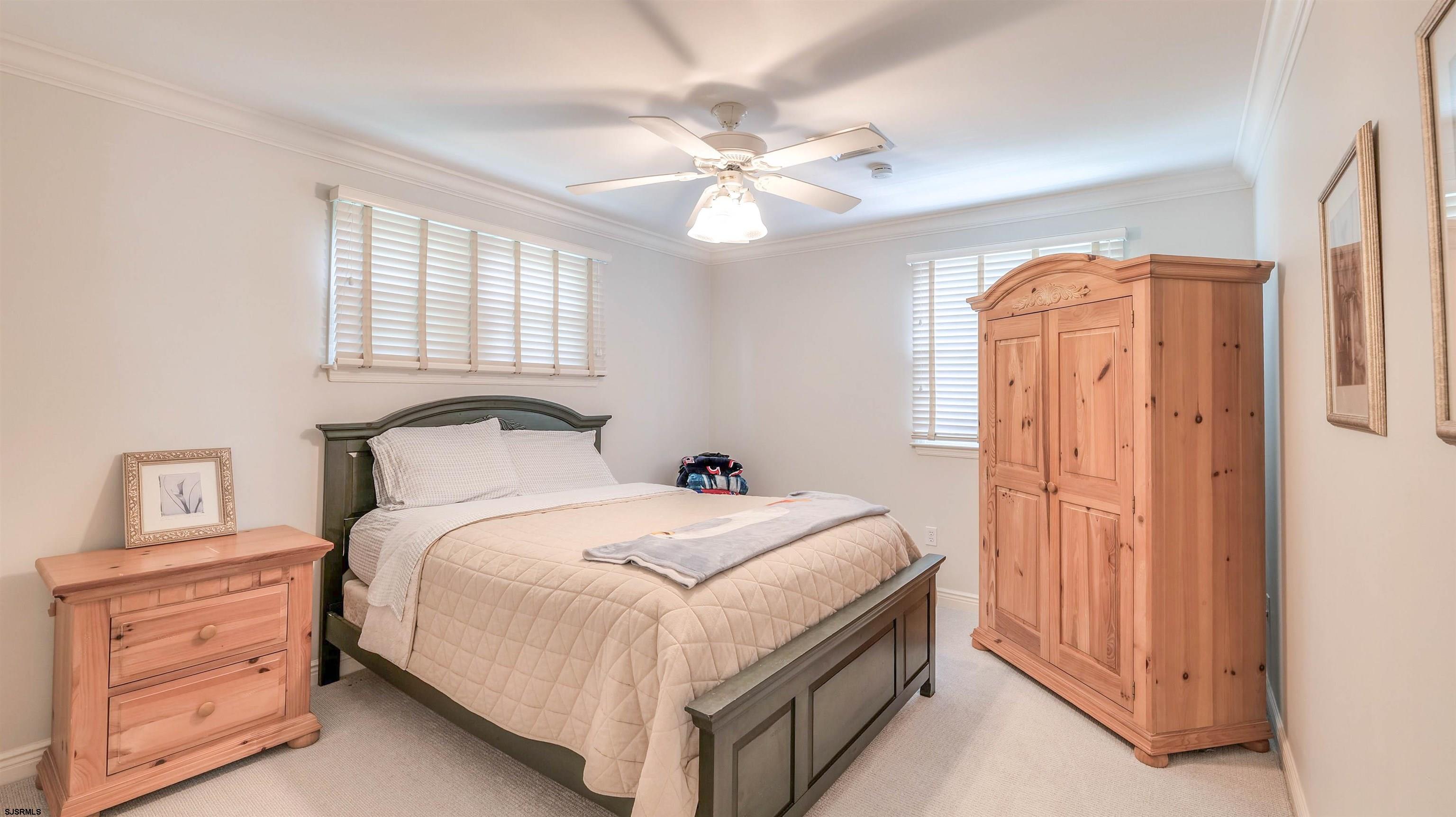 6 North Lancaster Avenue Margate City, NJ 08402 - Photo 25 of 32 a bedroom with a bed and a chandelier