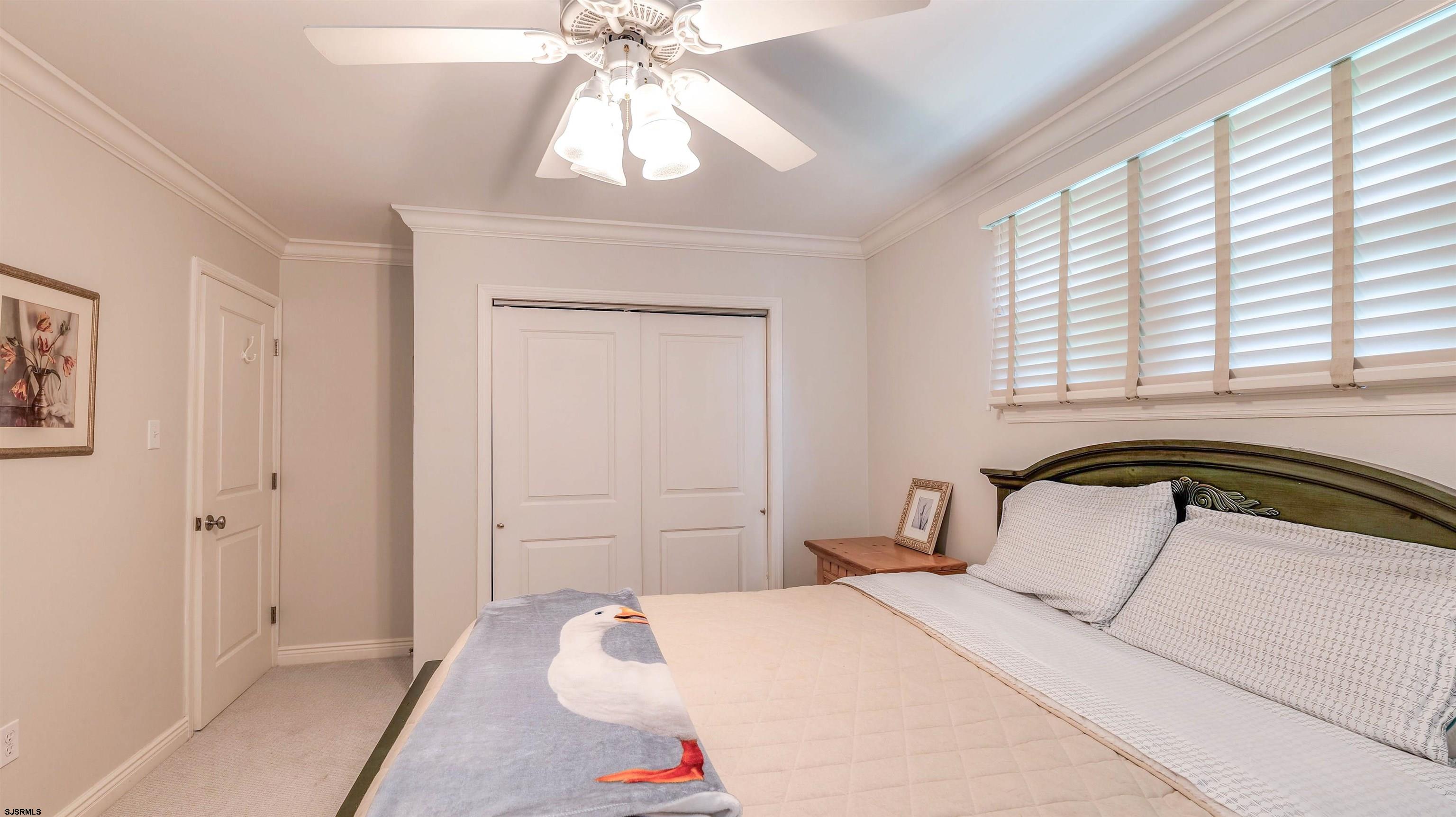 6 North Lancaster Avenue Margate City, NJ 08402 - Photo 26 of 32 a bedroom with a bed and a chandelier