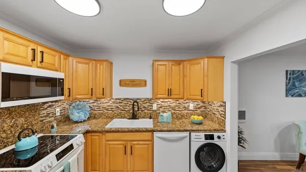 a kitchen with granite countertop a sink and a stove