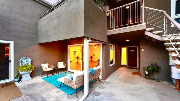 a view of a patio with table and chairs near a barbeque