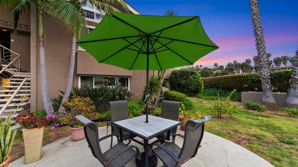a view of a patio with a table and chairs under an umbrella