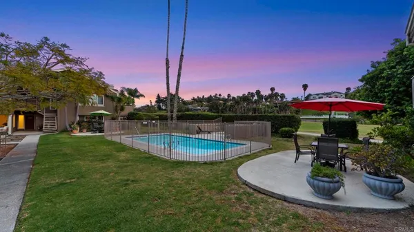 a view of a swimming pool with a patio and a yard