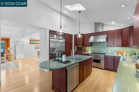 a kitchen with stainless steel appliances granite countertop a sink a stove and a refrigerator