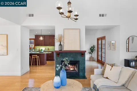 a living room with furniture a fireplace and kitchen view