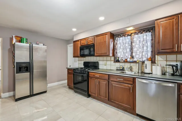 a kitchen with stainless steel appliances granite countertop a refrigerator a sink a stove a microwave a counter space and cabinets