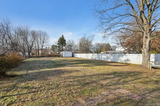 a view of a swimming pool with outdoor seating and trees in the background