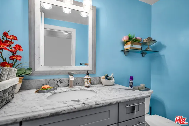a bathroom with a granite countertop sink and a mirror