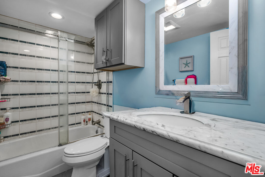 18411 Hatteras Street, Unit 114 Tarzana, CA 91356 - Photo 15 of 19 a bathroom with a granite countertop sink toilet and shower