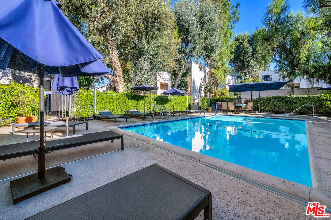 18411 Hatteras Street, Unit 114 Tarzana, CA 91356 - Photo 2 of 19 a view of a patio with swimming pool table and chairs