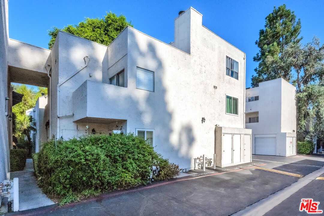 18411 Hatteras Street, Unit 114 Tarzana, CA 91356 - Photo 7 of 19 a view of a house with a yard and potted plants