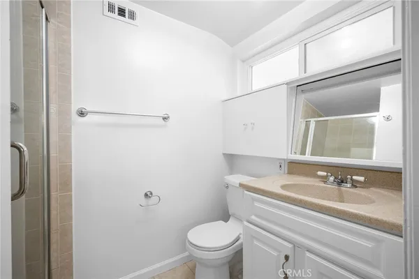 a bathroom with a granite countertop sink toilet and a mirror