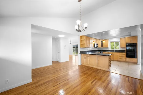 a large kitchen with stainless steel appliances granite countertop a large counter top and wooden floors
