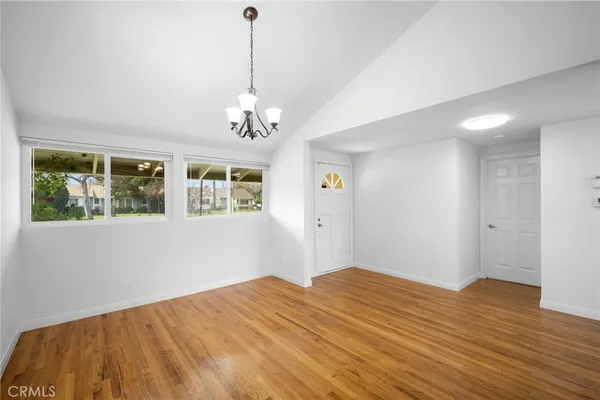 a view of empty room with wooden floor and window