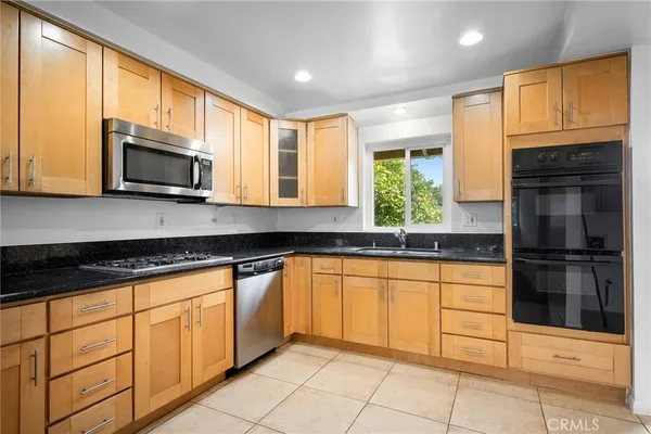a kitchen with stainless steel appliances granite countertop a stove sink and microwave