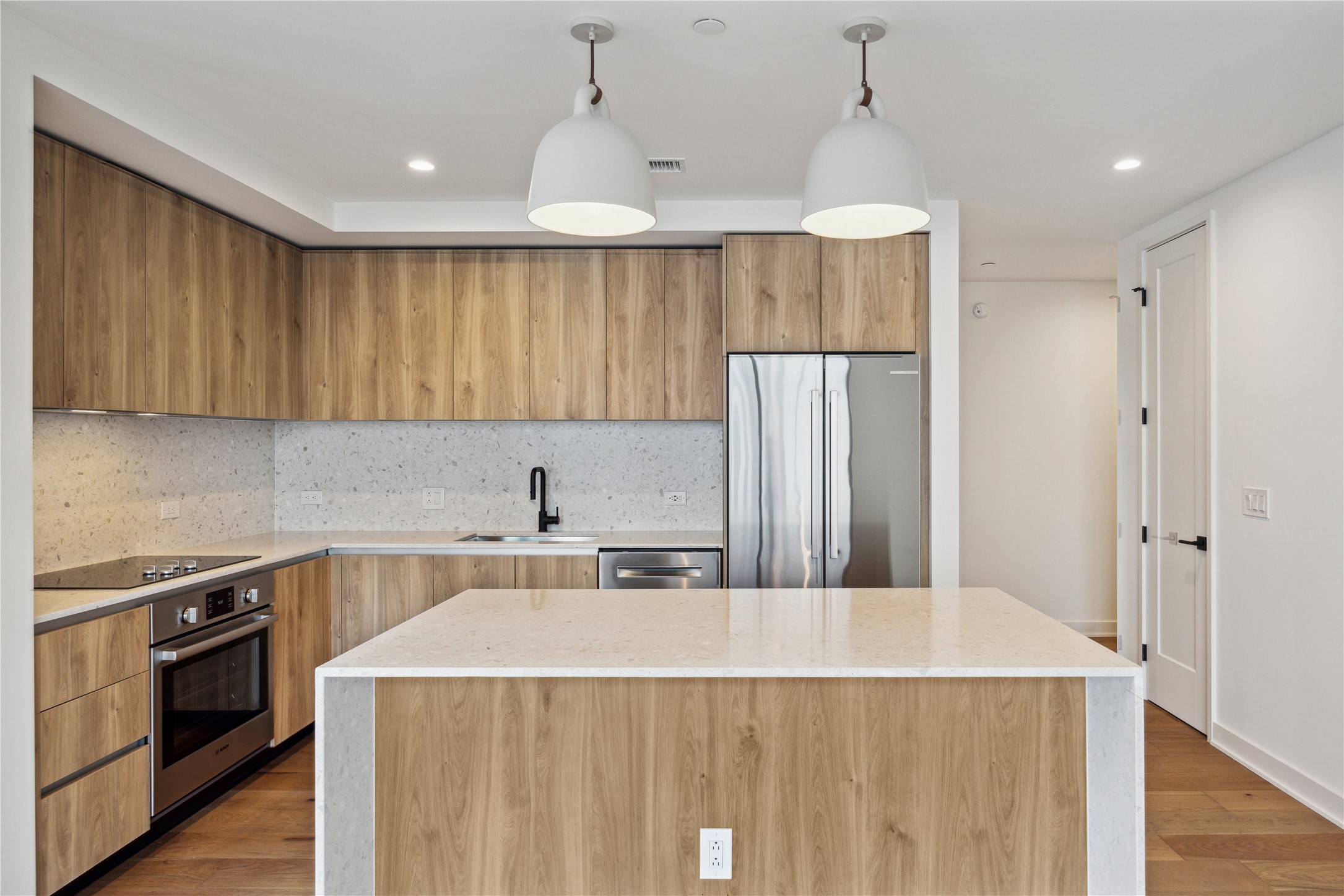 84 East Avenue, Unit 3009 Austin, TX 78701 - Photo 13 of 39 a kitchen with kitchen island a stove a sink a refrigerator and cabinets