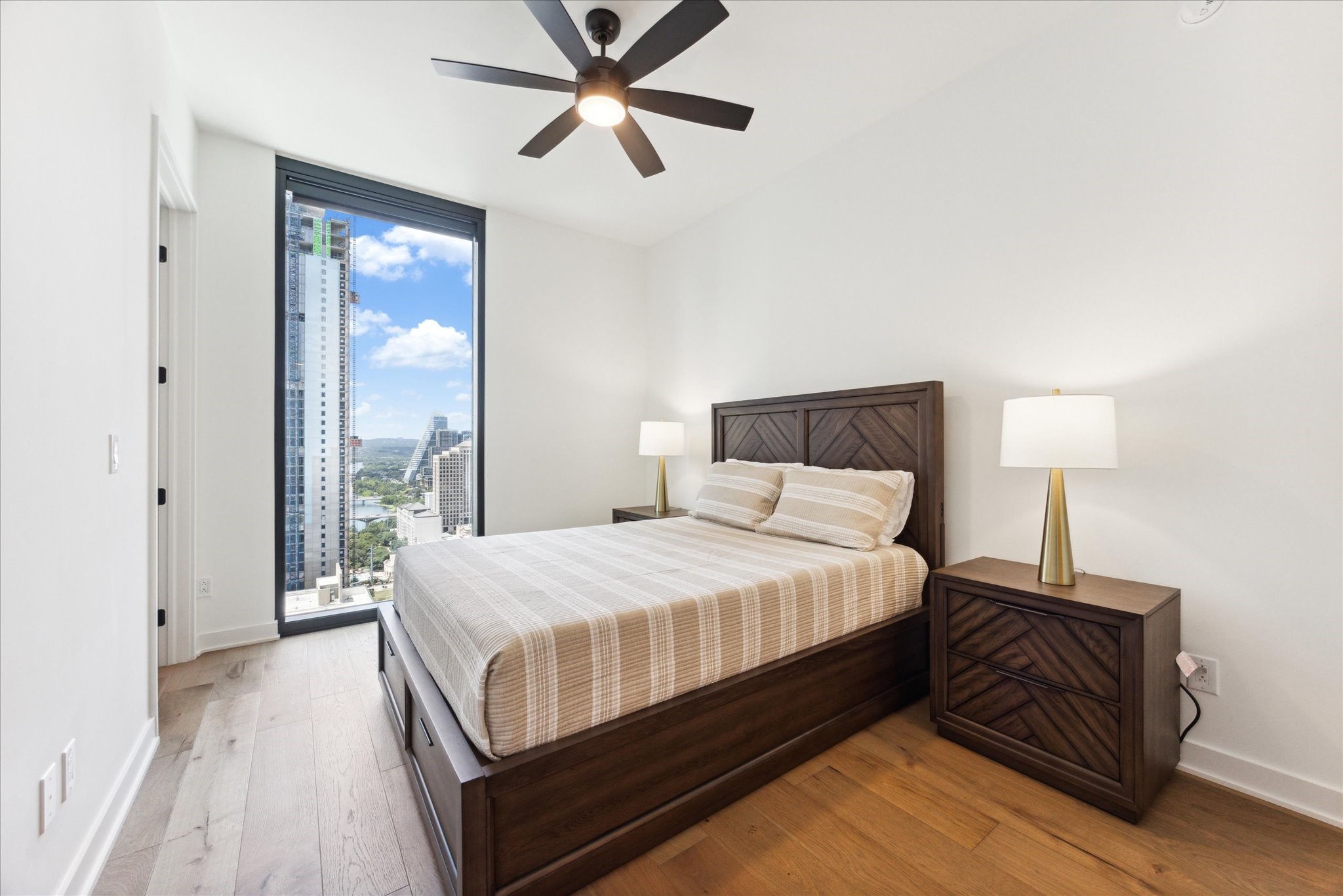 84 East Avenue, Unit 3009 Austin, TX 78701 - Photo 15 of 39 a bedroom with a large bed and a chandelier