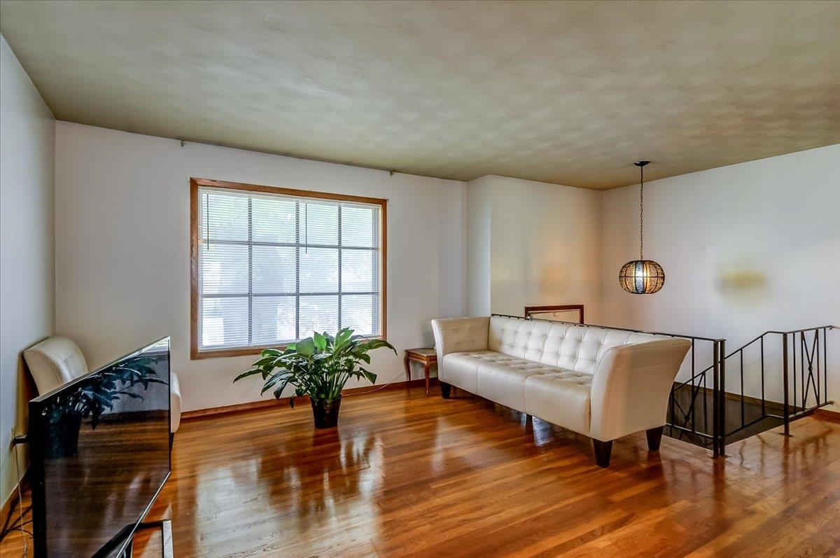 2569 Rozelle Street Memphis, TN 38114 - Photo 11 of 30 Hardwood flooring throughout featuring a large picture window with wood trim