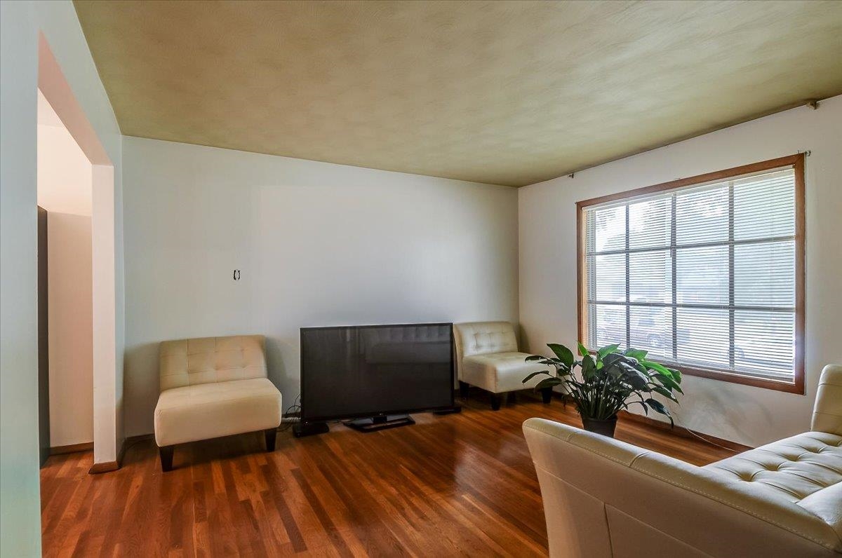 2569 Rozelle Street Memphis, TN 38114 - Photo 13 of 30 Hardwood flooring complements white walls and a large multi-pane window with wood trim