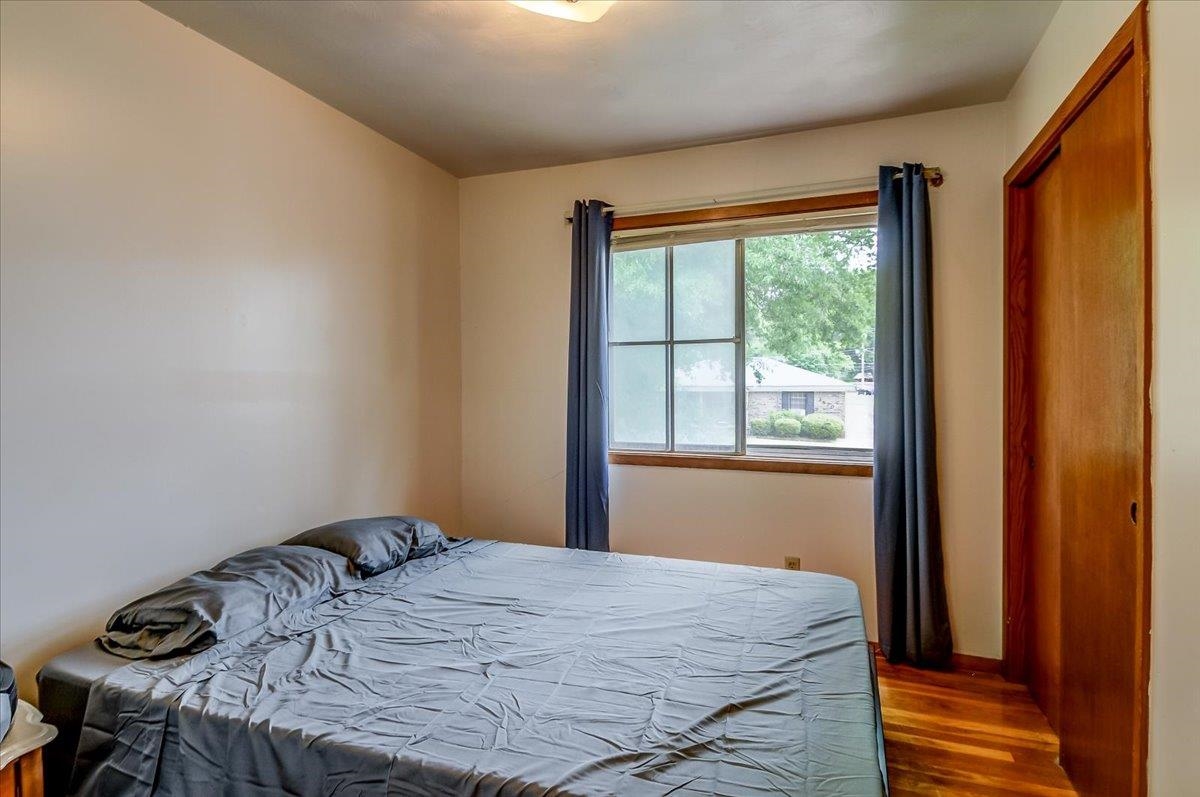 2569 Rozelle Street Memphis, TN 38114 - Photo 19 of 30 Bedroom featuring wood-finish flooring, a window with exterior views, and a wood-panel closet door