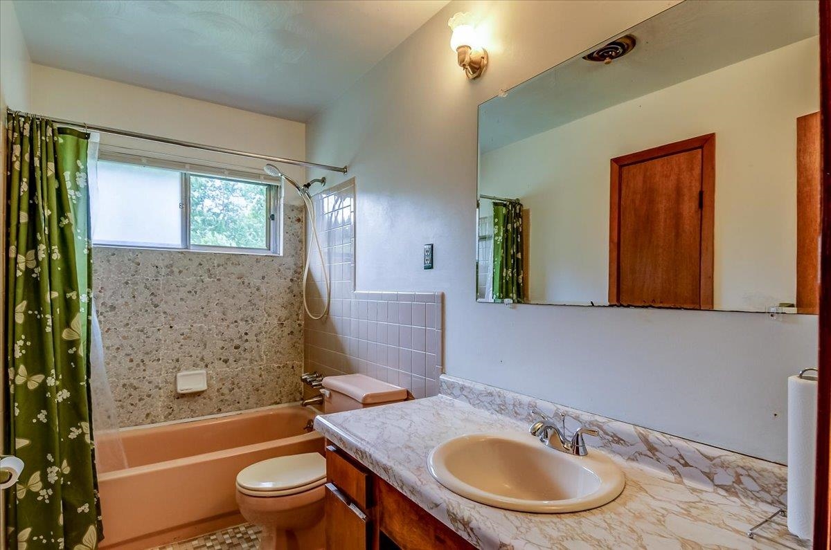 2569 Rozelle Street Memphis, TN 38114 - Photo 21 of 30 Bathroom featuring a vanity with a laminate countertop and integrated sink, a large wall-mounted mirror, and a full bathtub with a shower