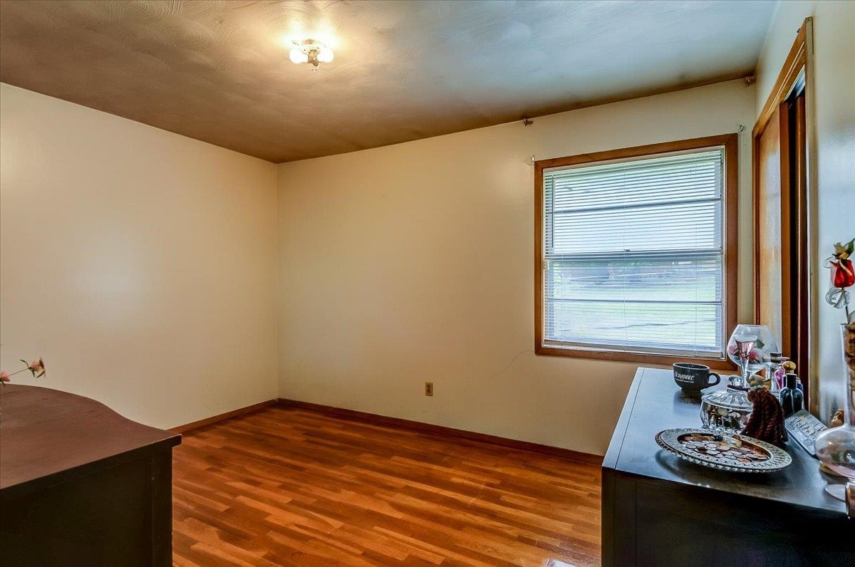 2569 Rozelle Street Memphis, TN 38114 - Photo 22 of 30 Bright room with wood-finish flooring, a window featuring horizontal blinds, and a flush-mount ceiling light fixture
