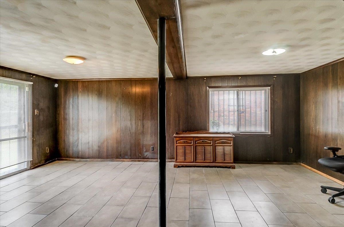2569 Rozelle Street Memphis, TN 38114 - Photo 5 of 30 Interior room featuring wood-panel walls, light-toned tile flooring, and a sliding glass door