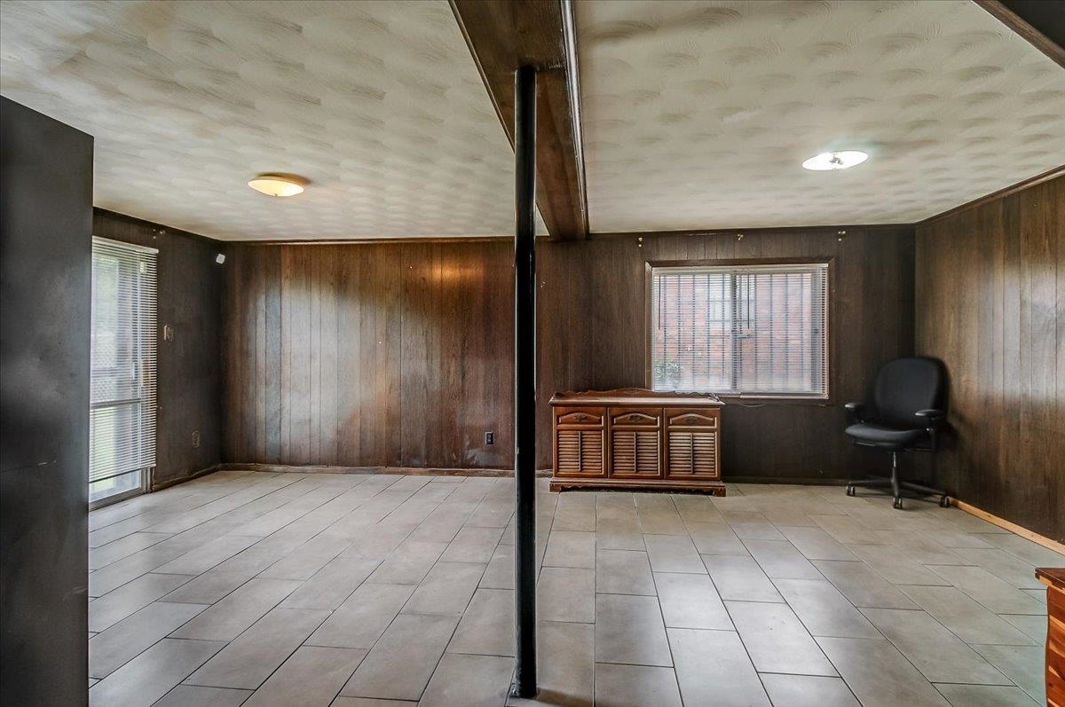 2569 Rozelle Street Memphis, TN 38114 - Photo 7 of 30 Spacious room featuring wood paneling, light-toned tile flooring, and a sliding glass door