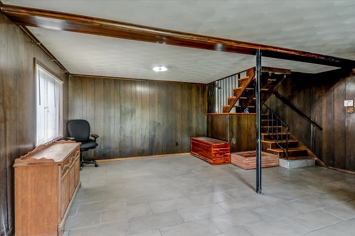 2569 Rozelle Street Memphis, TN 38114 - Photo 8 of 30 Finished lower level featuring paneled walls, a single window, and a built-in staircase with metal railings