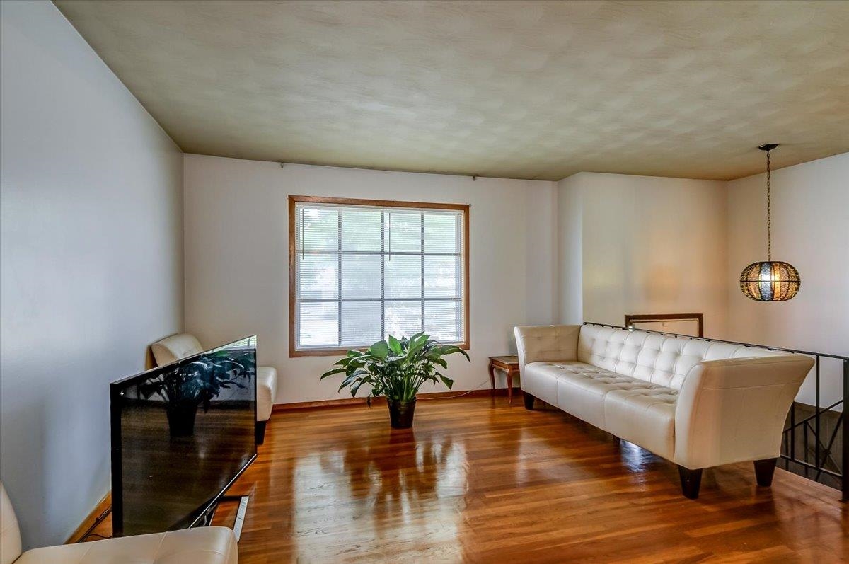 2569 Rozelle Street Memphis, TN 38114 - Photo 10 of 30 Luminous interior with polished wood-finish flooring, a large multi-pane window, and a distinctive hanging light fixture