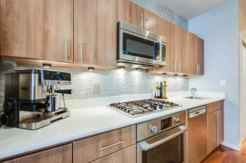 a kitchen with stainless steel appliances granite countertop a sink stove and microwave