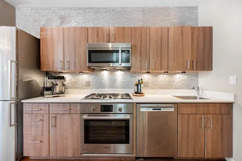 a kitchen with appliances a sink a stove a microwave and cabinets