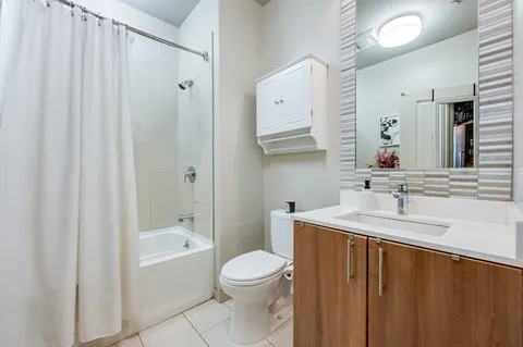 a bathroom with a sink a toilet and a large mirror