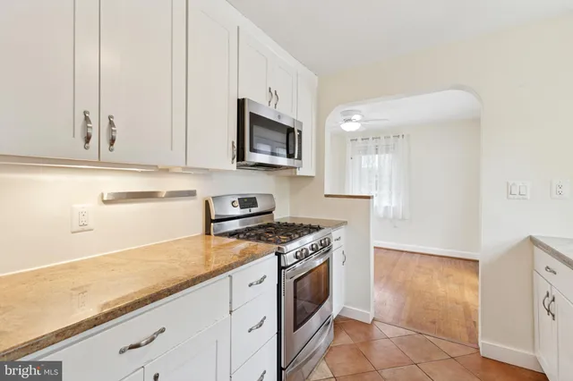 a kitchen with granite countertop cabinets stainless steel appliances and a counter space