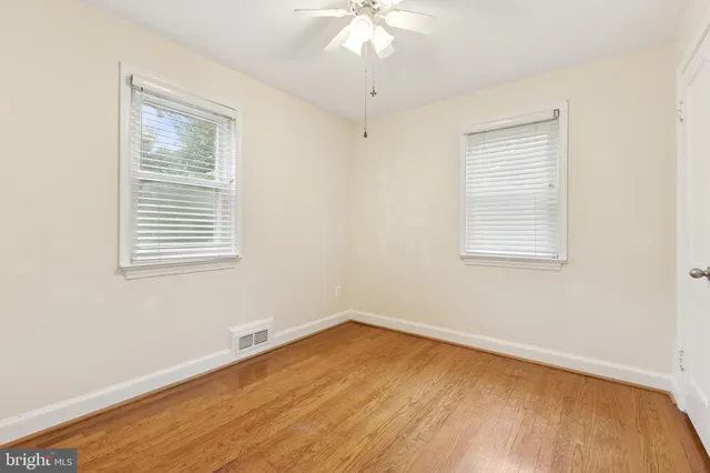 a view of a room with wooden floor and windows