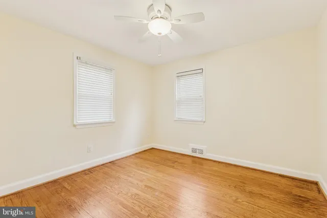 an empty room with a window and a ceiling fan