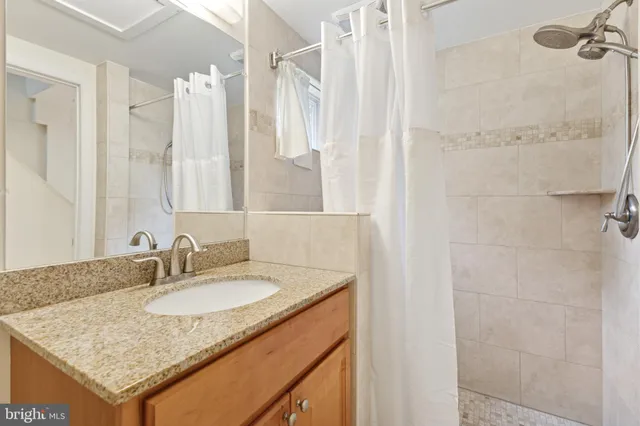 a bathroom with a granite countertop sink and a mirror