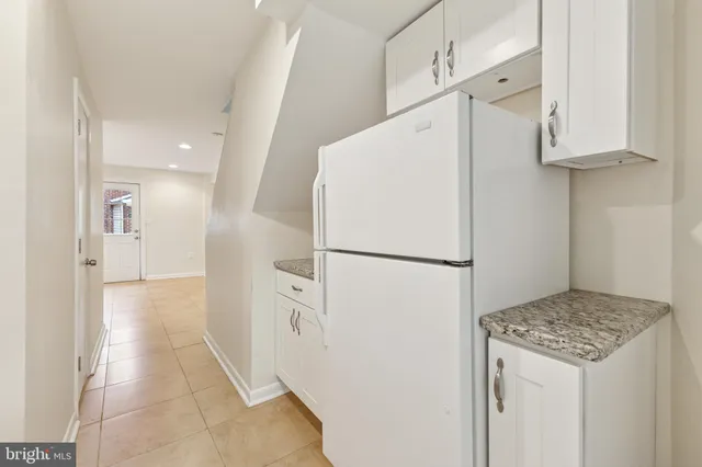 a white refrigerator freezer and a stove sitting inside of a kitchen