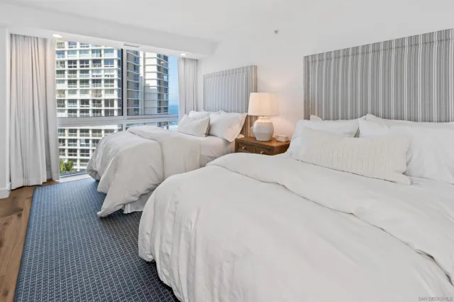 a bed room with two beds and a large window