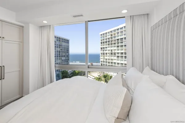a bed sitting in a spacious bedroom next to a window
