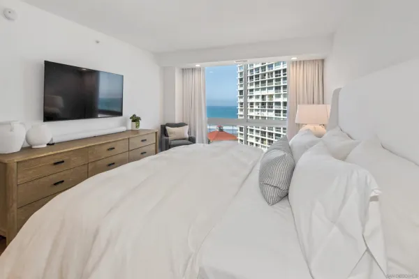 a bedroom with a large bed and a flat screen tv