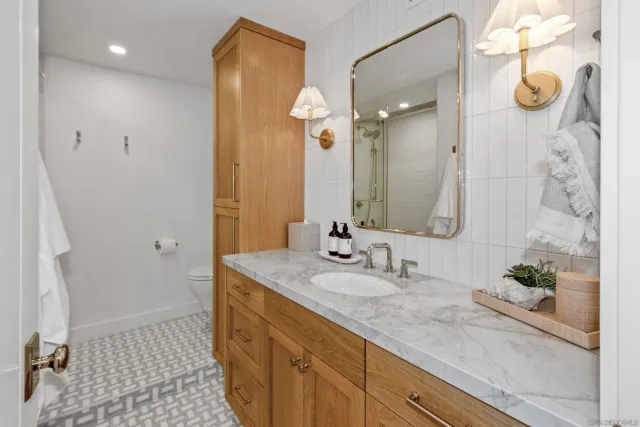 a bathroom with a granite countertop sink a mirror and a shower