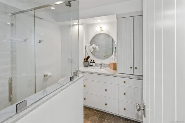 a bathroom with a double vanity sink mirror and shower