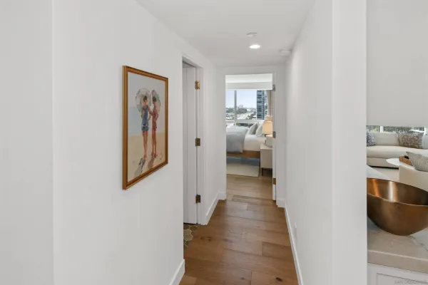 a view of a hallway with the view and closet with wooden floor