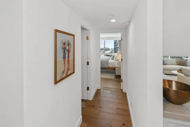 a view of a hallway with the view and closet with wooden floor