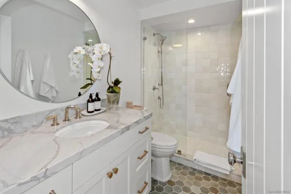 a bathroom with a granite countertop sink a toilet and shower