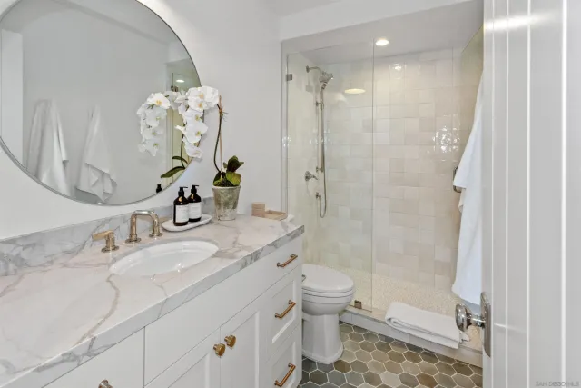a bathroom with a granite countertop sink a toilet and shower