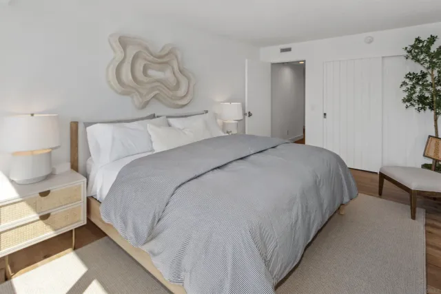 a bedroom with bed and a potted plant