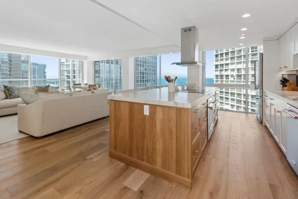 a living room with furniture a large window and wooden floor