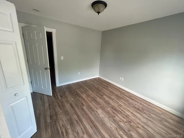 an empty room with wooden floor and entrance